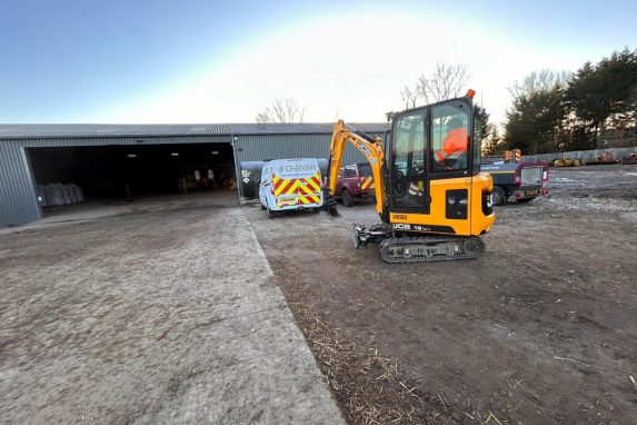 mini excavartor on site with van